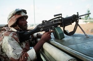 A member of the 15th Marine Expeditionary Unit mans an M-249 Squad Automatic W0eapon  (SAW) as he maintains his position atop an AAVP-7A1 amphibious assault vehicle en route to the airport.  Marines are in the region during the multinational relief effort Operation Restore Hope.