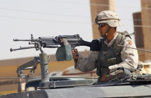 US Army (USA) Specialist Fourth Class (SFC) Heriberto Santiago, 554th Military Police (MP) Company (CO), attached to the 173rd Airborne Brigade helps provides perimeter security with an FNMI 5.56 mm M249 Squad Automatic Weapon (SAW), during a meeting between an American commander and a local sheik outside of Kirkuk, Iraq, during Operation IRAQI FREEDOM.