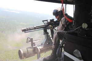 Staff Sgt. Jared Sberal, a quality assurance representative with Marine Light Attack Helicopter Squadron 467, fires the GAU-17 six barreled Gatling machine gun at mock targets below in support of Exercise Mailed Fist.