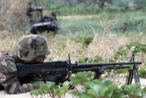 A US Army M60 machine gunner waits for aggressor forces while defending Trajillo Beach during Exercise SOLID SHIELD '87.