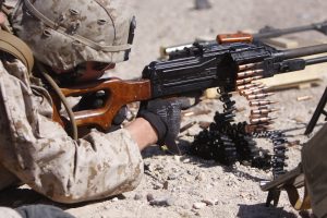 Lance Cpl. Christopher Mooney, a Marine training with Police Mentor Team 1st Battalion, 10th Marine Regiment, fires the PKM machine gun July 14 at Combat Center Range 113A.